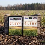 Tablet i książka „Rewitalizacja gleby” oparte o skrzynkę na skraju pola